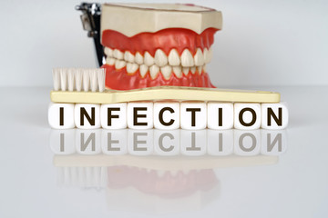 Medical, dental concept. The text is written on the cubes - INFECTION. In the background is a model...