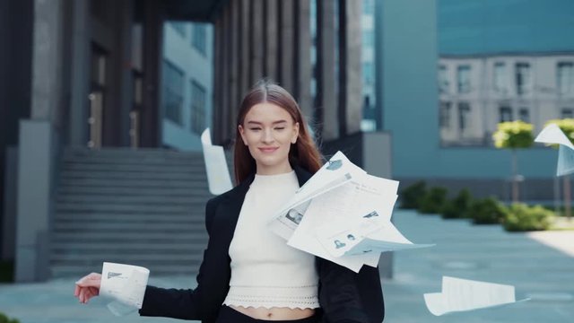 Happy woman finished the project, throwing papers, freedom after work, success in business. Businesswoman smiles and laughs, winner won the competition, emotions from victory. Student defended thesis