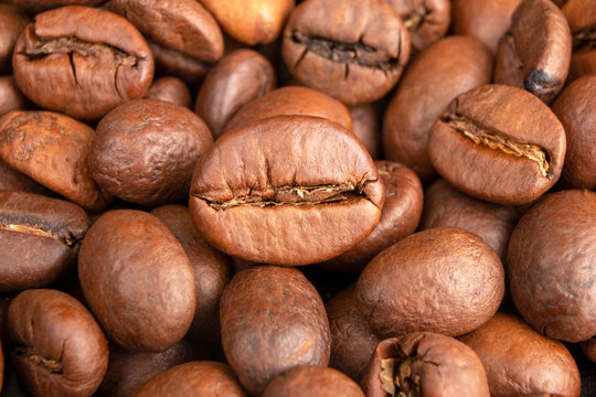 Roasted Coffee beans background close up. International coffee day concept. Macro photography foods. Texture for design. © alia.kurianova