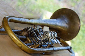 Old trumpet - wind musical instrument. Shallow depth of field. Background is blurred