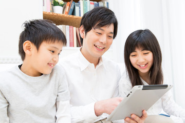 タブレットPCを見る父子 © Paylessimages
