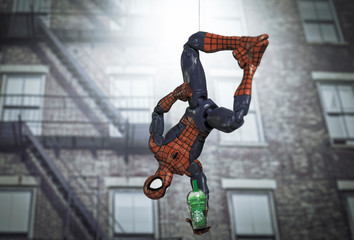 Naklejka premium NEW YORK USA, AUGUST 19 2020: superhero Spiderman hanging upside down from a web with a Starbucks Frappuccino - Hasbro Legends action figure