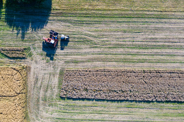 Fototapeta na wymiar Aerial top down view of combine harvester working in the field, harvesting time