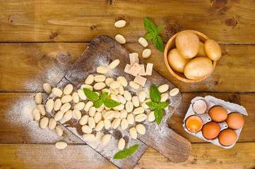Gnocchi with potatoes. Traditional italian food from Rome, Sardinia, south of italy. Homemade gnocchi with parmesan, egg, cornmeal (semolina). On a wooden table. High quality photo. Above. Copy space 