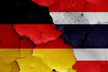 flags of Germany and Thailand painted on cracked wall