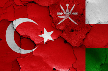 flags of Turkey and Oman painted on cracked wall