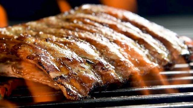 Grilled pork ribs on the flaming grill.