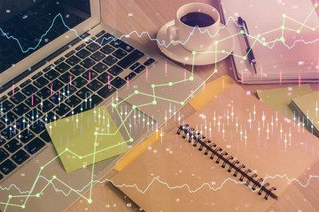 Multi exposure of forex graph drawing and desktop with coffee and items on table background. Concept of financial market trading