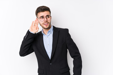 Young caucasian business man posing in a white background isolated Young caucasian business man trying to listening a gossip.