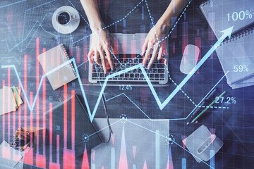 Multi exposure of woman hands working on computer and forex chart hologram drawing. Top View. Financial analysis concept.