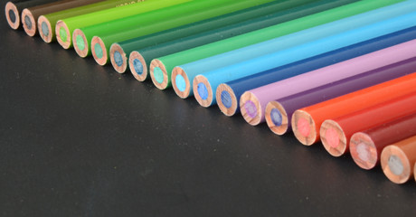Fototapeta premium color pencils on dark background, aligned color pencils