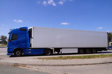 A blue truck with a white trailer. Break in a trip.
