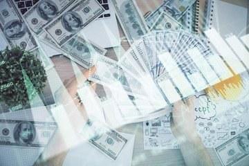 Multi exposure of financial graph drawing hologram and USA dollars bills and man hands. Analysis concept.