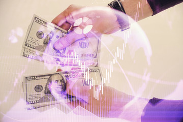 Multi exposure of financial graph drawing hologram and USA dollars bills and man hands. Analysis concept.