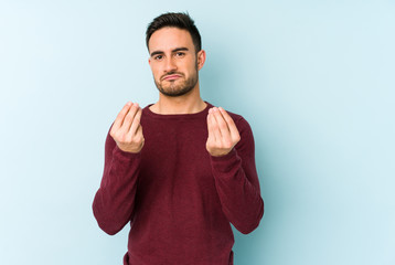 Young caucasian man isolated on blue background showing that she has no money.