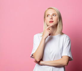 Blonde woman in white moch-up tshirt on pink background