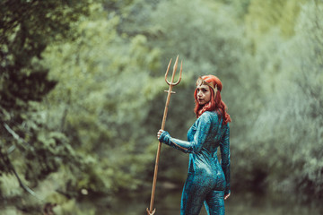 Redhead woman posing with superhero costume