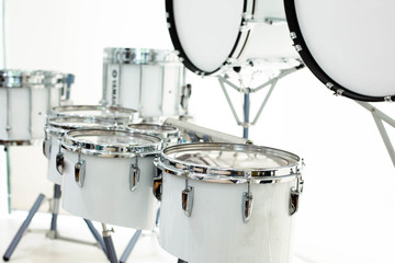 Drum snare with blurry big drum of marching band on white background.