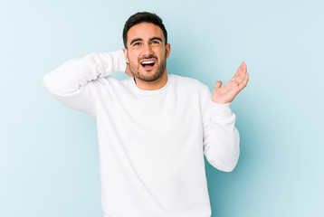 Fototapeta premium Young caucasian man isolated on blue background screaming with rage.