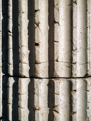 Fototapeta premium Element of a classic column in the form of cannelures in light marble. Background from the texture of natural stone.