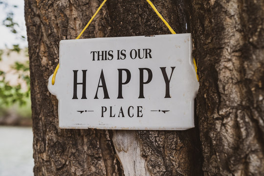 Outdoor Sign Hung On A Tree Reading, This Is Our Happy Place