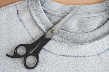upcycling old clothes concept, sweatshirt with scissors to cut a new neckline