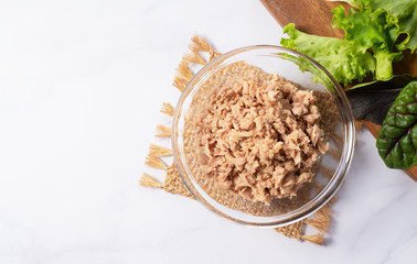 Tuna in a glass bowl set in a marble