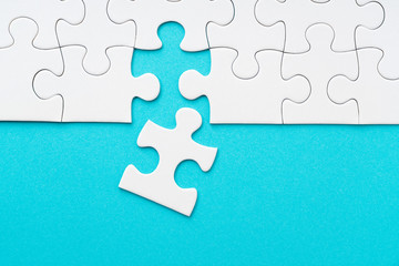 Blue background and white jigsaw puzzle viewed from above
