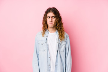 Fototapeta premium Long hair man posing isolated confused, feels doubtful and unsure.
