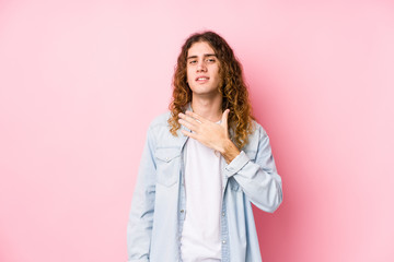 Long hair man posing isolated laughs out loudly keeping hand on chest.