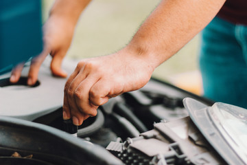 Manos mecánico arreglando motor de carro