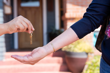 Real estate agent giving keys to the buyer of a new house