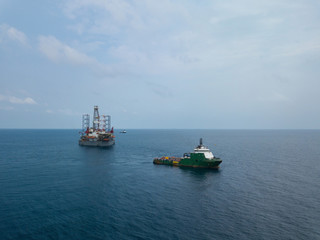 Aerial view offshore jack up rig and a tow vessel at the offshore location