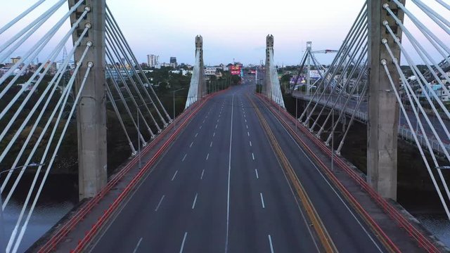 Empty, desolate and deserted Puente Juan Pablo Duarte bridge and highway lanes, Santo Domingo, Dominican Republic, coronavirus pandemic and restriction, overhead rising aerial drone