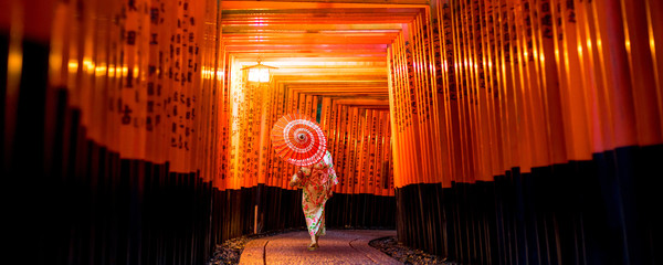 Japans meisje in Yukata met rode paraplu bij Fushimi Inari Shrine