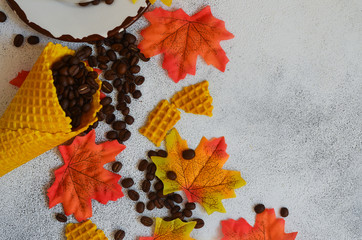 Autumn background with copy space for text and design. A cup of coffee, coffee beans waffle cones...