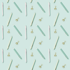 Creative seamless pattern with office supplies, white and green colored pens and metal paper clips.