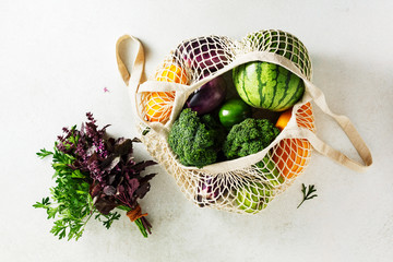 Reusable shopping bags with vegetables, zucchini, eggplant, watermelon. Top view. Sustainable lifestyle concept.
