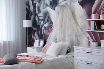Teenage girl's room interior with comfortable bed and floral wallpaper. Idea for stylish design © New Africa