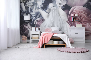 Teenage girl's room interior with comfortable bed and floral wallpaper. Idea for stylish design © New Africa