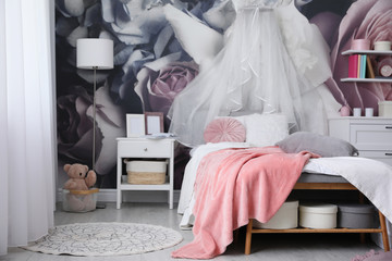 Teenage girl's room interior with comfortable bed and floral wallpaper. Idea for stylish design
