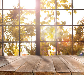 Empty wooden table near window on sunny autumn day