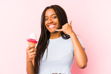 Young african american woman holding an ice cream isolated showing a mobile phone call gesture with fingers.