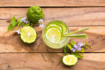 herbal healthy drinks iced kaffir lime cocktail water with bergamot slice local flora of asia arrangement flat lay style on background wooden - obrazy, fototapety, plakaty