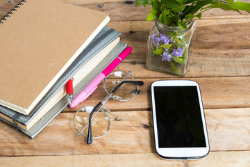 notebook planner and mobile phone for business work arrangement flat lay style on background wooden