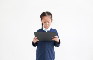 Portrait of asian little child girl in school uniform using tablet isolated on white background. Studio shot