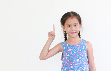 Asian little child girl pointing forefinger up isolated on white background with copy space.