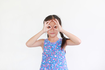 Kid with hands glasses in front of her eyes isolated on white background. Little asian girl looking through imaginary binocular.