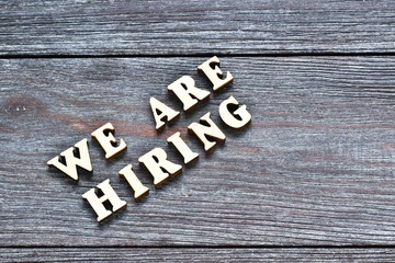 Words We are hiring on wooden background. Job board. Human Resource Management and Recruitment and Hiring concept.