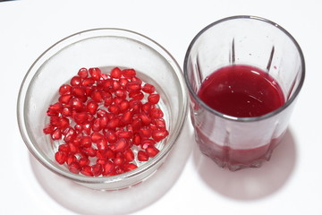 Fresh pomegranate seeds with juice on white background